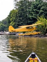 Plane w w rack of canoes in background.jpg Plane w w rack of canoes in background.jpg